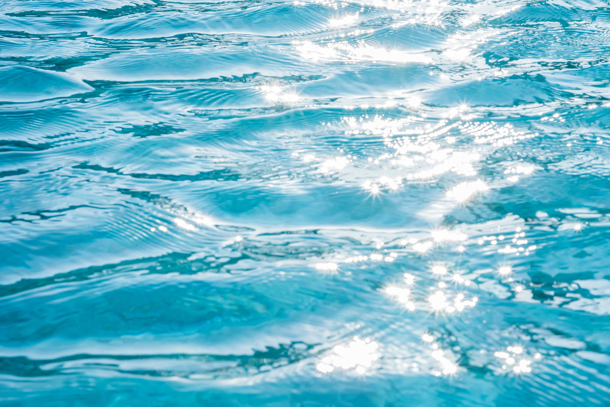 Sunlight reflecting on gently rippling blue water.